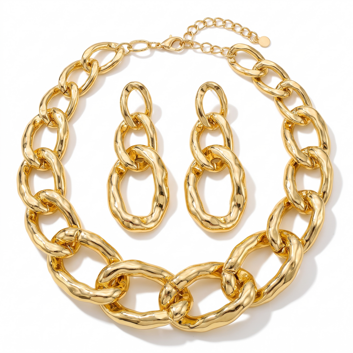Collier grosse maille dorée et paire de boucles d'oreilles assorties, sur fond blanc
