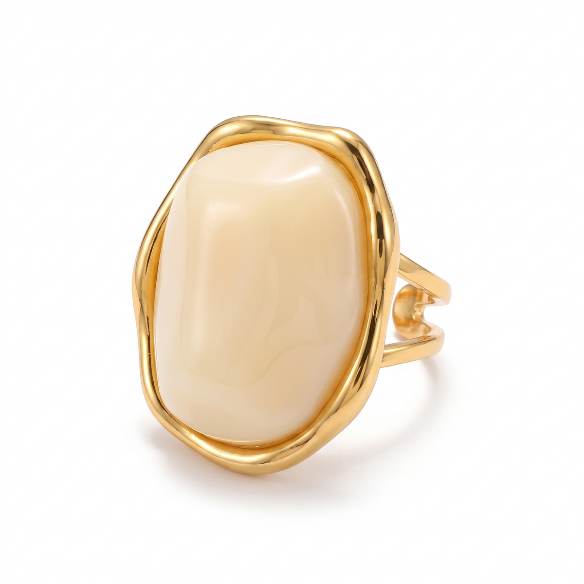 Bague dorée sertie d'un gros cabochon ivoire, sur fond blanc