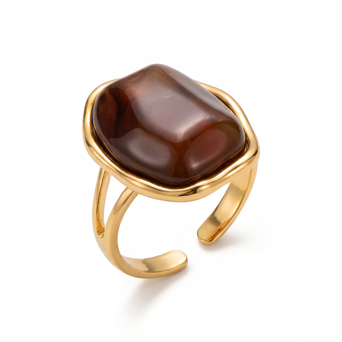 Bague dorée sertie d'un gros cabochon brun brillant, sur fond blanc