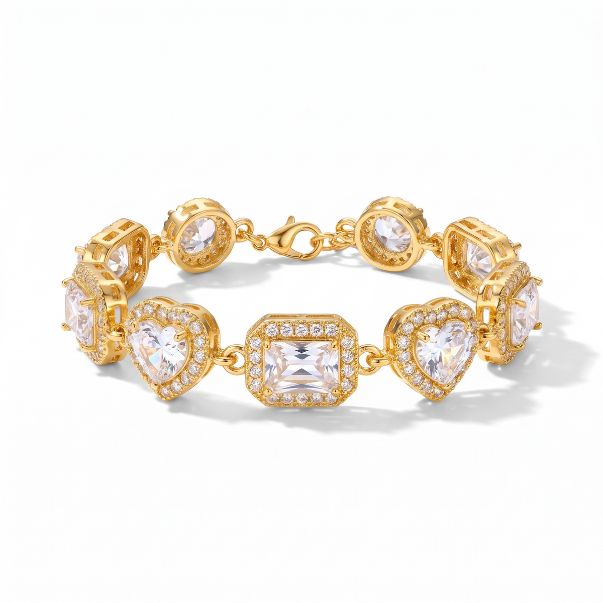 Bracelet doré serti de gros cristaux de synthèse en forme de cœurs, rectangles et ronds, sur fond blanc
