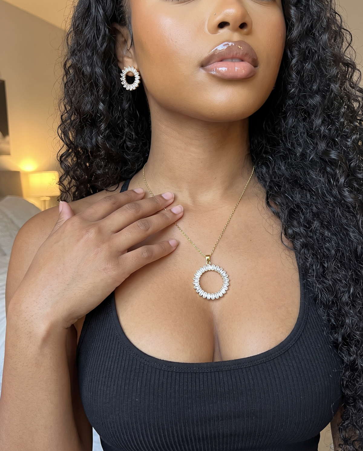 Collier soleil en zircons porté au cou avec ses puces, débardeur noir