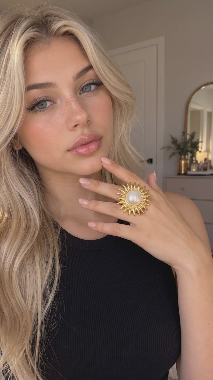Vidéo : bague perle dorée en forme de soleil portée au doigt